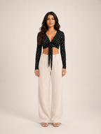 Black long-sleeve V-neck crop top with tied front and scattered micro-print