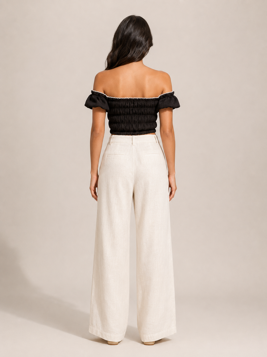 Black off-shoulder smocked top with puff sleeves, back view with gathered elastic