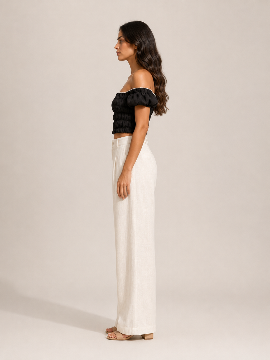 Black off-shoulder smocked top with puff sleeves, side profile with gathered back