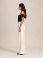 Black off-shoulder smocked top with puff sleeves, side profile with gathered back