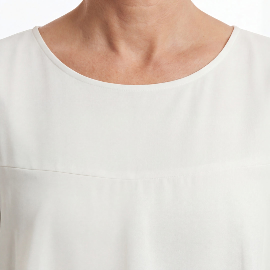 Close-up of white round neckline and smooth bodice of tiered ruffle dress