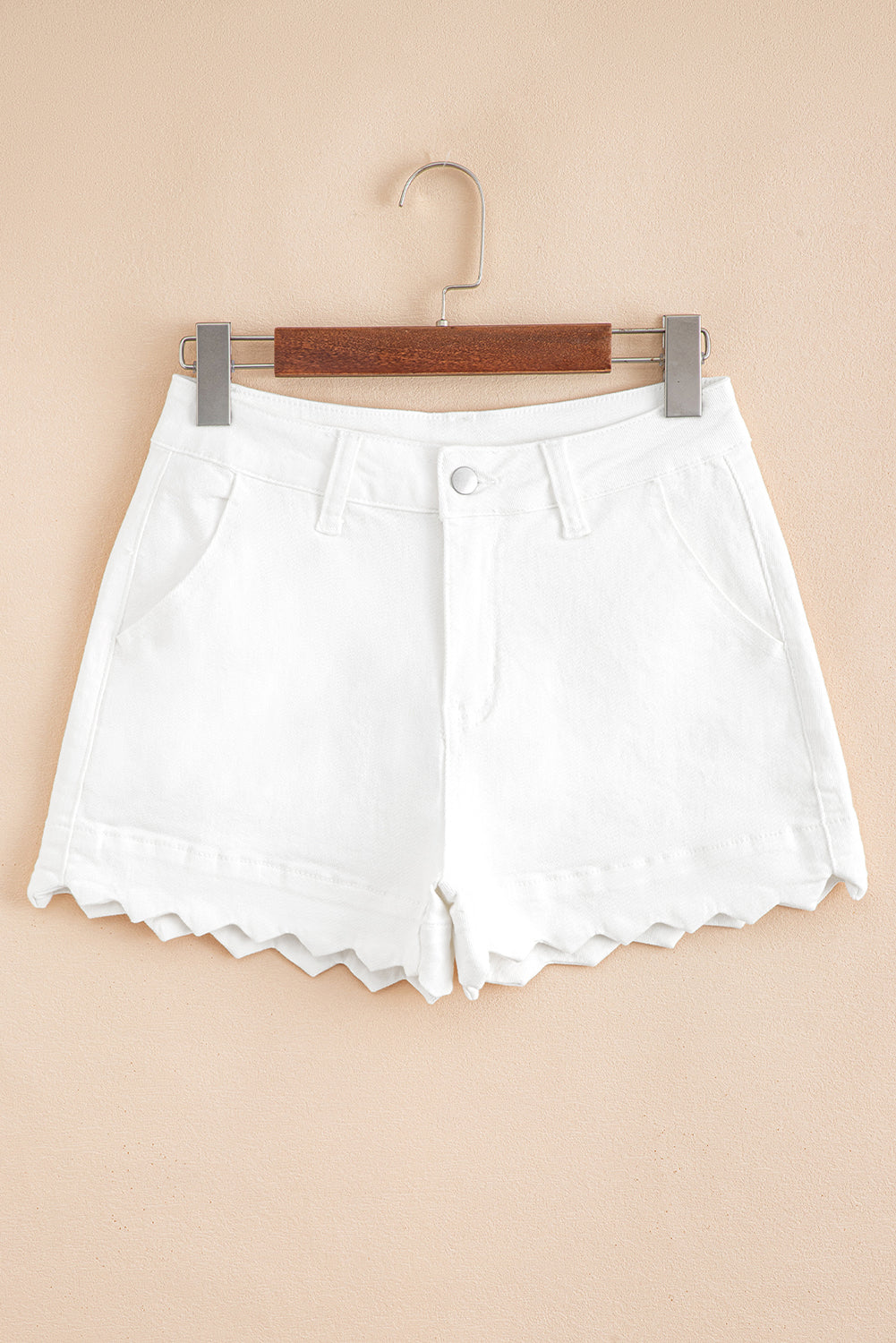 White denim shorts on hanger, high waist with button closure and scalloped hem
