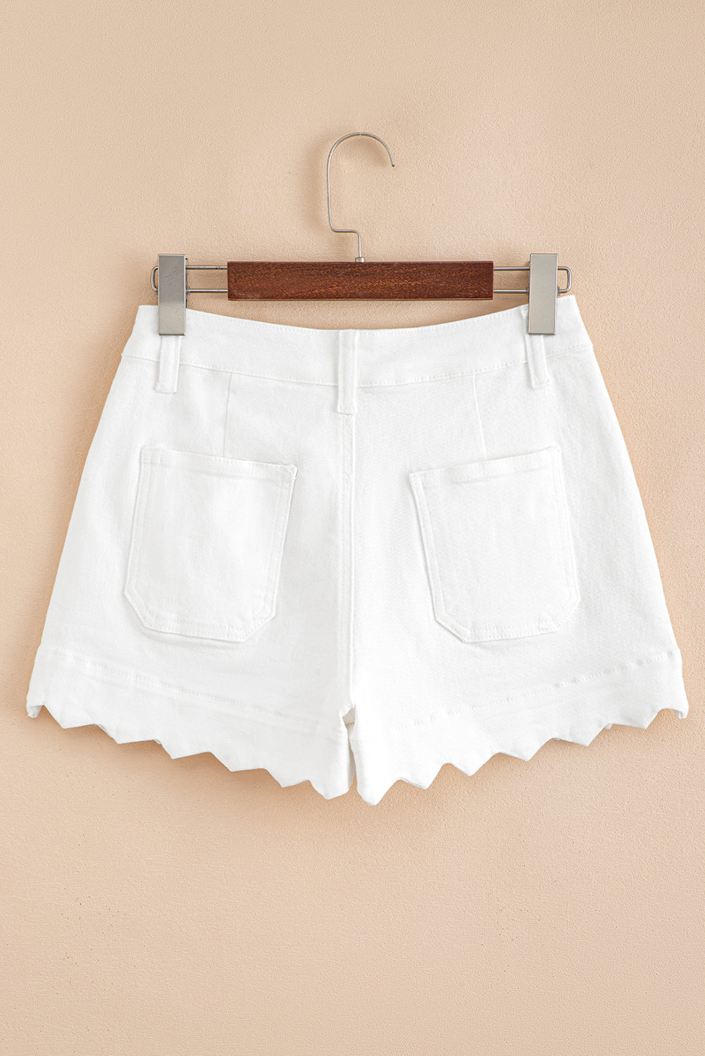 White denim shorts on hanger, high waist, scalloped hem, front patch pockets