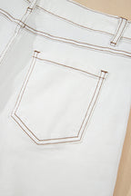 White denim shorts front pocket detail with contrast orange stitching and topstitching.