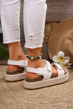 White platform sandals with double Velcro straps and open toe, close-up