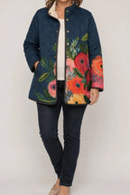 Wearbella navy quilted jacket with large colorful floral print, snap front, and side pockets.