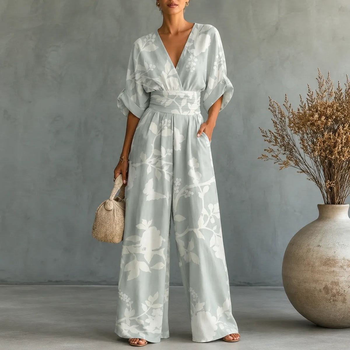 Women's leafy V-neck wide-leg jumpsuit with cinched waist and pockets, light blue.