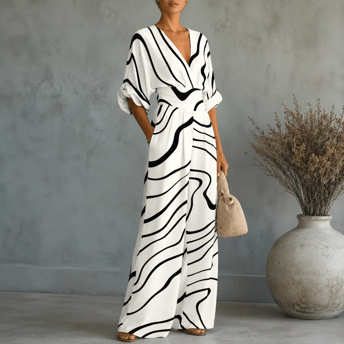 Women's abstract stripe V-neck wide-leg jumpsuit with cinched waist and pockets, white/black.