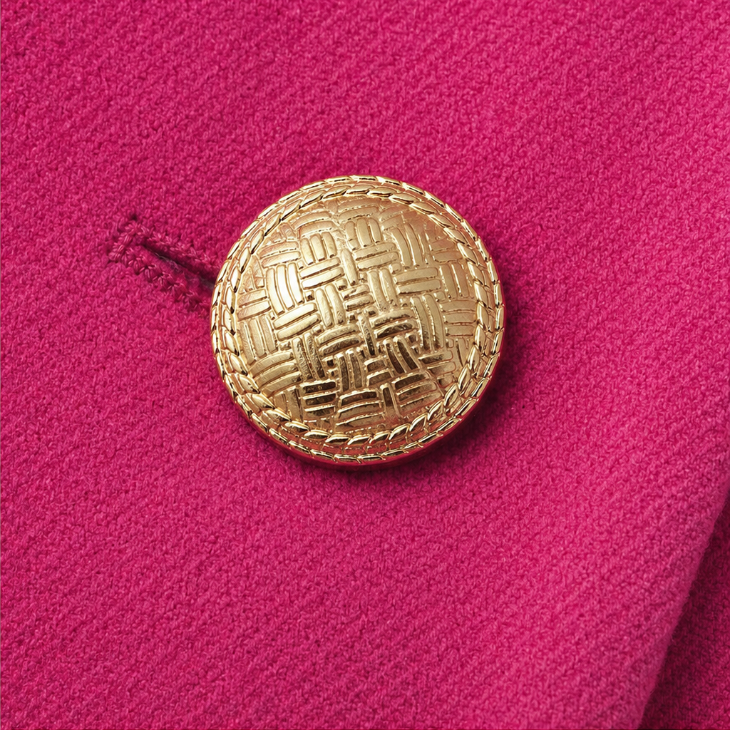 Wearbella coat detail with textured fuchsia fabric and a round gold button