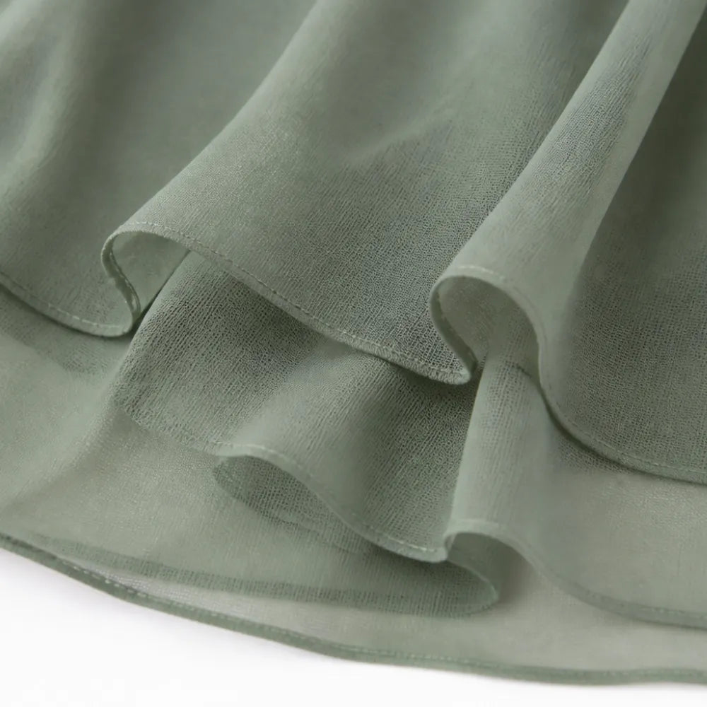 Sage green chiffon skirt hem with soft layered drape