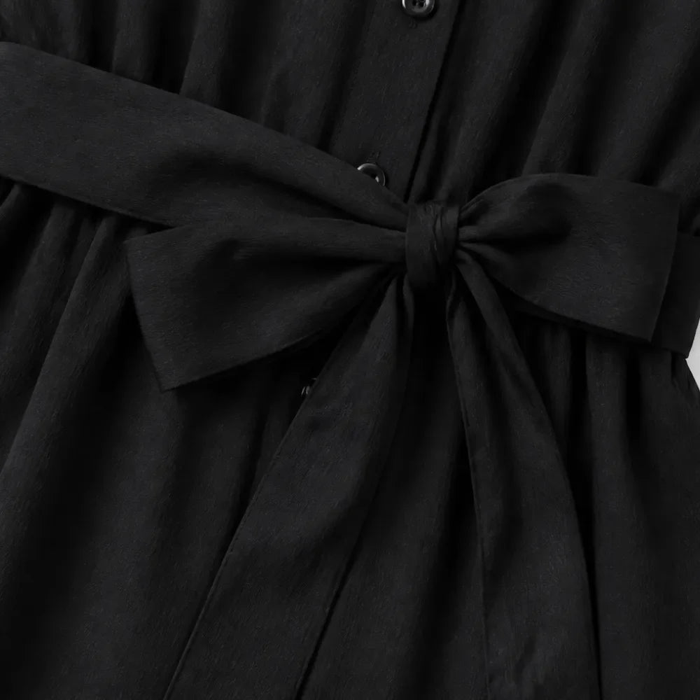 Black shirt jumpsuit waist tie detail with gathered fabric and button placket