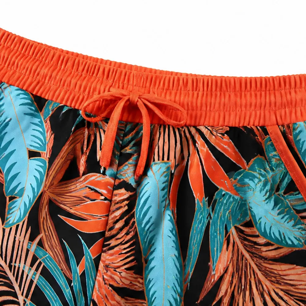 Tropical leaf swim shorts with elastic waist and orange drawstring tie