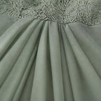 Sage green pleated chiffon-look skirt section under embroidered lace bodice