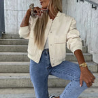 Women’s bomber jacket in cream, button front, chest flap pockets, ribbed sleeves.