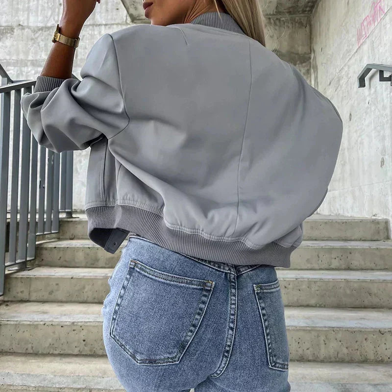 Women’s bomber jacket in light gray, button front, ribbed cuffs, chest pockets.