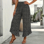 Black smocked wide-leg ruffle trousers with elastic waist and small white floral print