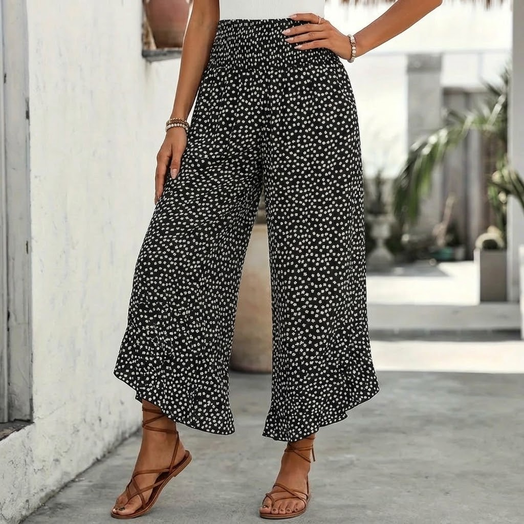 Black smocked wide-leg ruffle trousers with elastic waist and small white floral print
