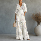 Women's floral V-neck wide-leg jumpsuit with cinched waist and pockets, cream.
