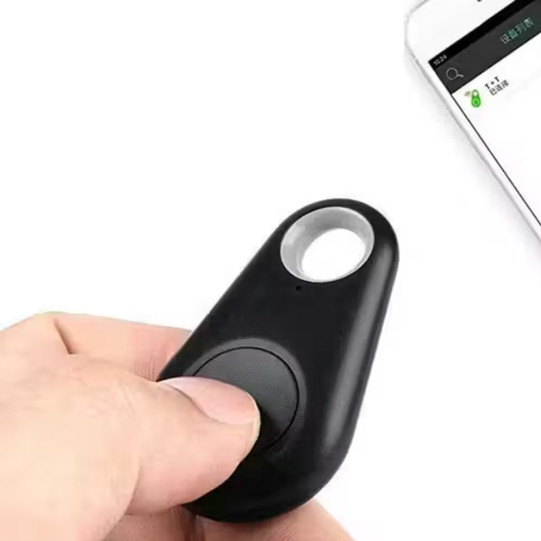 Black GPS mini tracker held in hand with ring hole and button