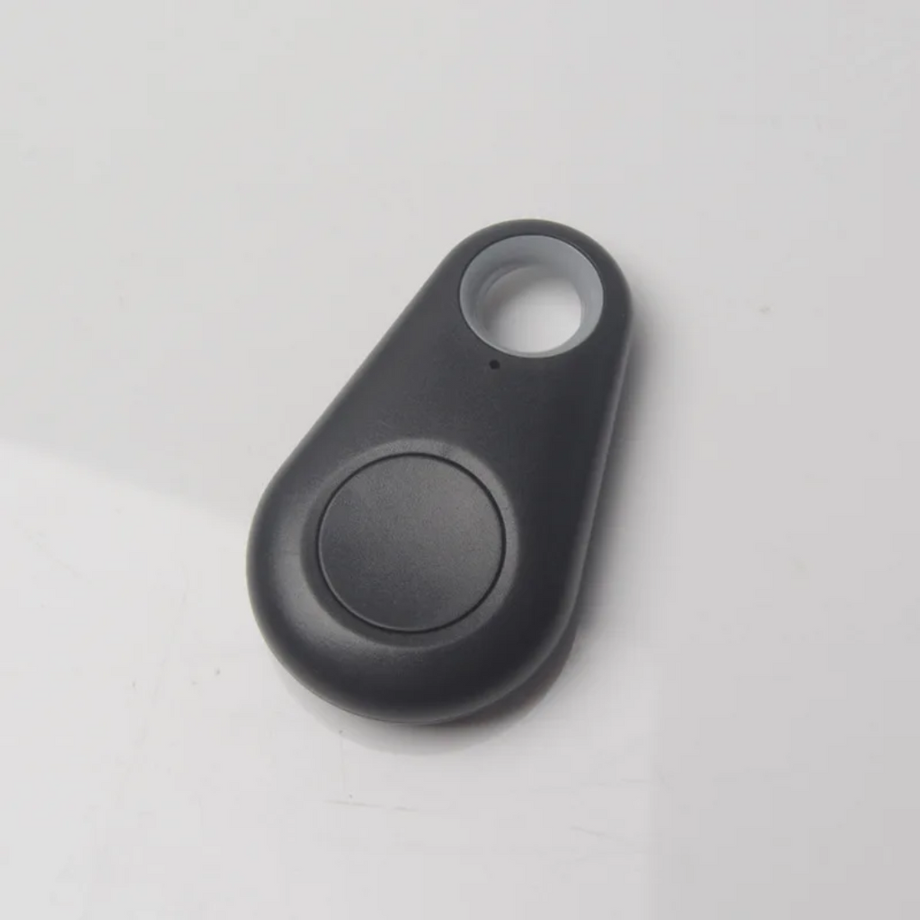 Black mini GPS tracker key finder close-up with circular button and attachment loop.